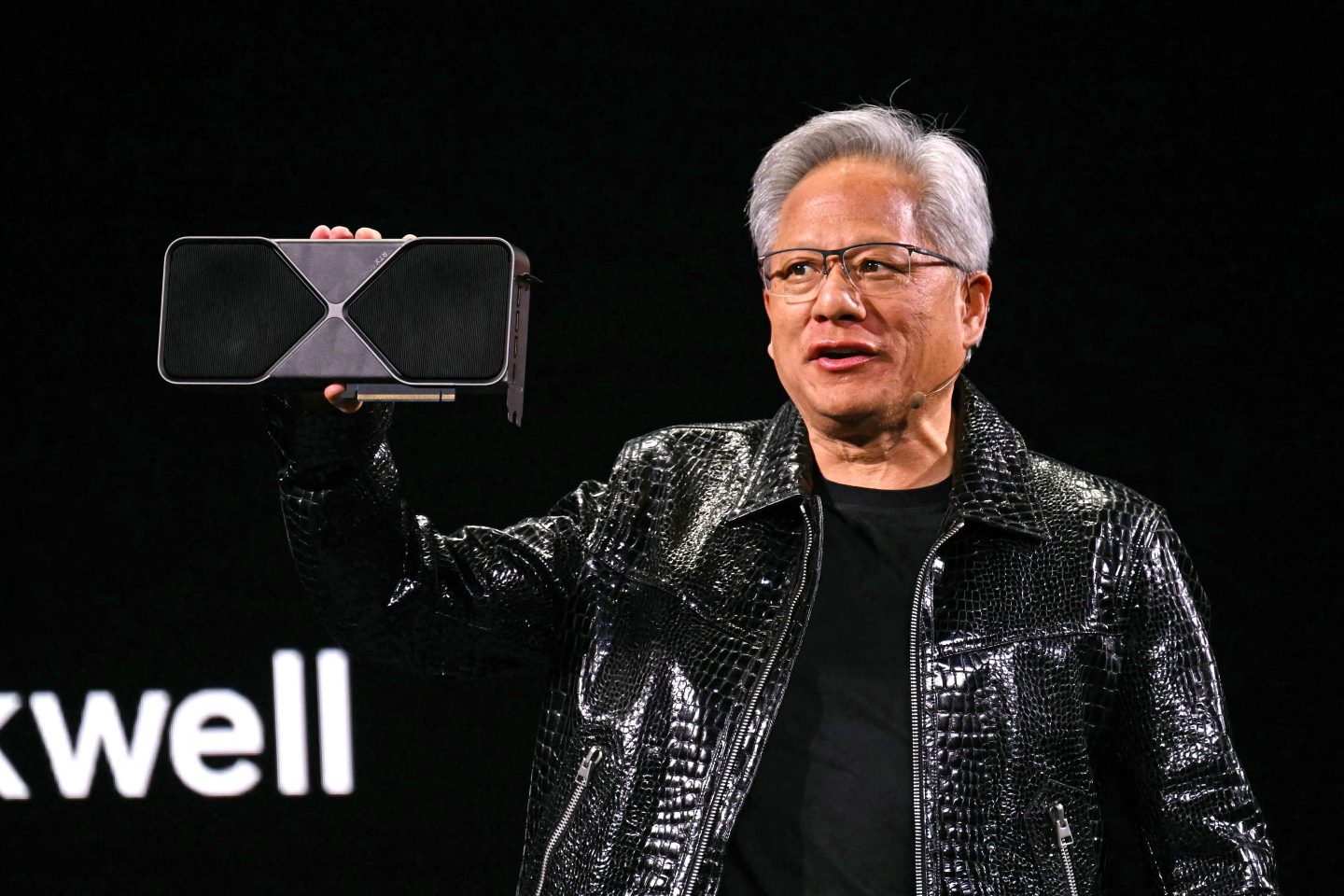 Nvidia CEO Jensen Huang holds a Blackwell GeForce RTX 50 Series GPU as he delivers a keynote address at the Consumer Electronics Show (CES) in Las Vegas, Nevada on January 6, 2025. Gadgets, robots and vehicles imbued with artificial intelligence will once again vie for attention at the Consumer Electronics Show, as vendors behind the scenes will seek ways to deal with tariffs threatened by US President-elect Donald Trump. The annual Consumer Electronics Show (CES) opens formally in Las Vegas on January 7, 2025, but preceding days are packed with product announcements. (Photo by Patrick T. Fallon / AFP) (Photo by PATRICK T. FALLON/AFP via Getty Images)